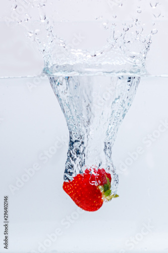 strawberry falling in water splash isolated on white background