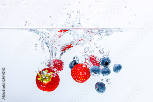 Grenadine fruits falling in water with a splash
