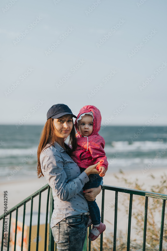 Mother and little daughter playing on the beach. Authentic image