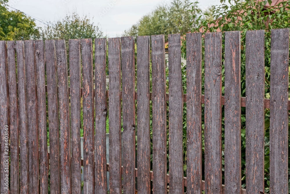 part of a brown fence from wooden boards on a rural street part of a brown fence from wooden boards on a rural street