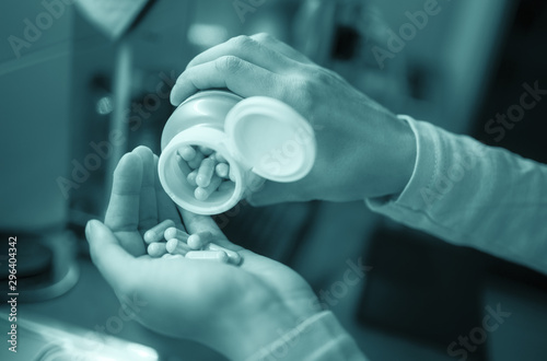 Selective focus on woman taking overdose of herbal supplement kratom capsules - Dangerous home alternative painkiller - Opioid addiction concept