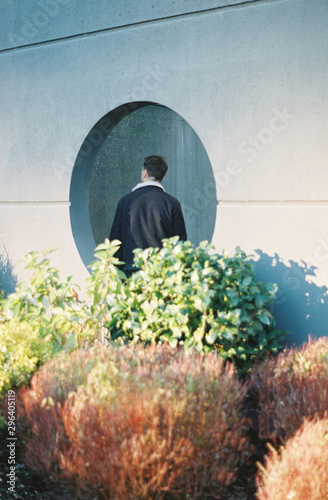 Back view of man standing near wall photo