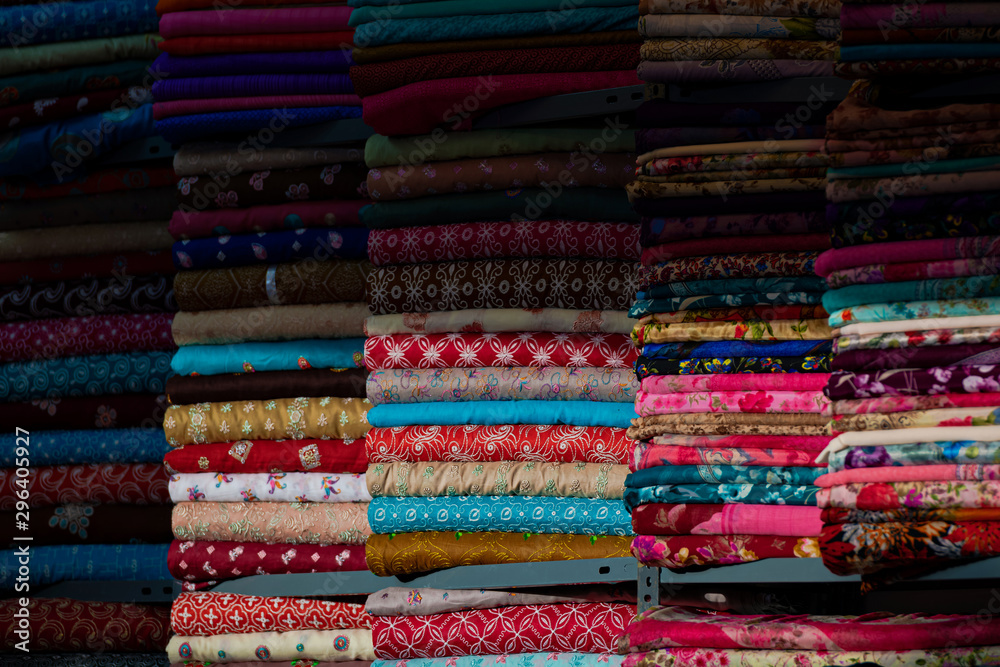 Partial lit textiles in vivid colors, ornaments on all of the fabrics