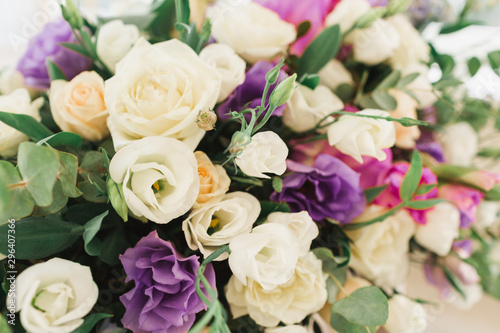 Floral wedding decoration. Wedding table setting decorated with fresh flowers. Wedding floristry. Bouquet with roses, eustoma and eucalyptus leaves. © olgamaer