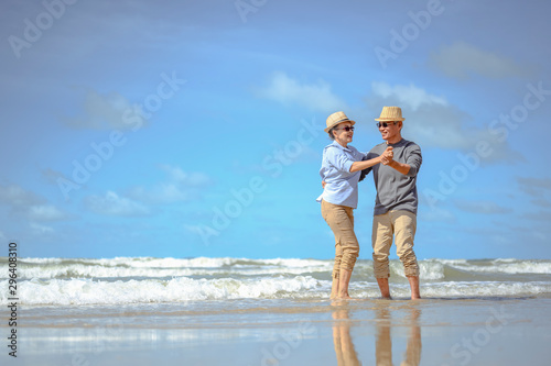 Senior couple dancing on the beach on good days, plan life insurance at retirement concept.