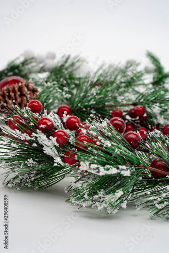 Concept New Year celebration background. Closeup photo of christmas tree decorated with red berries and cones. New Year card