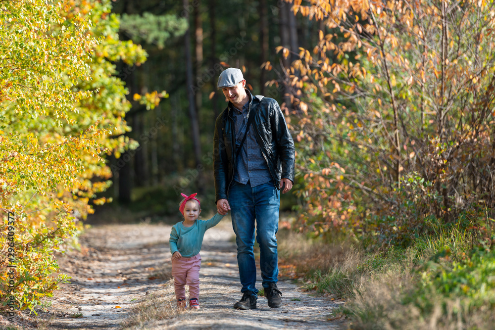 Fototapeta premium Happy loving family. Father and his daughter child girl playing and hugging outdoors. Cute little girl hugs daddy. Concept of Father's day. Authentic image