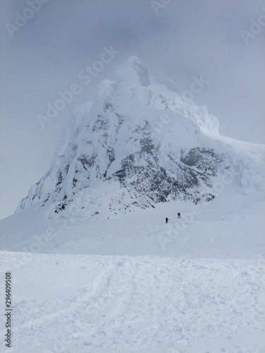 Two climber make their way up past Carter Rock, an old lave dome, on Mt. Hood as clouds close in. © Daniel