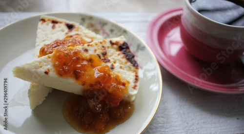 Traditional Finnish food Leipäjuusto with cloudberry jam and a cup of hot coffee.