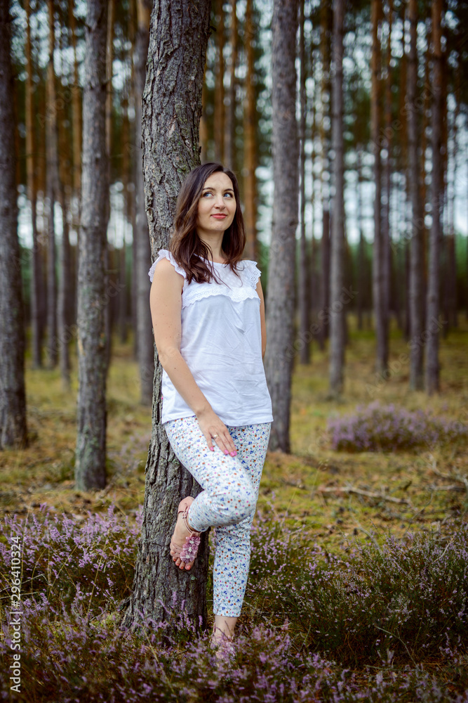a photo of woman in the forest where the purple heather blooms. copy space. authentic image. a photo of woman in the forest where the purple heather blooms. copy space. authentic image.