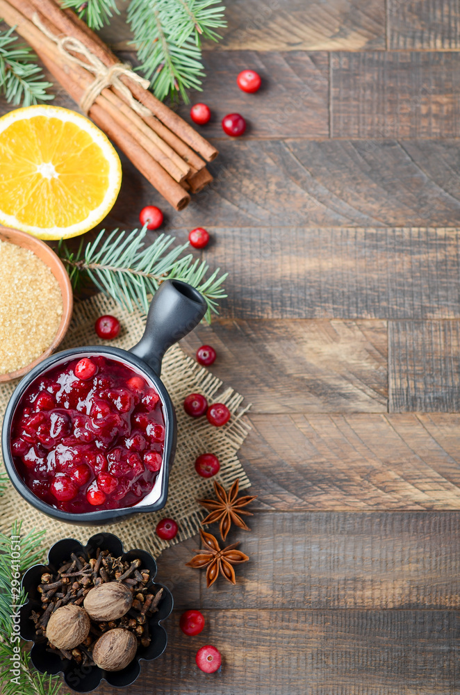 Cranberry sauce with ingredients on a wooden background. Top view, flat lay, copy space.