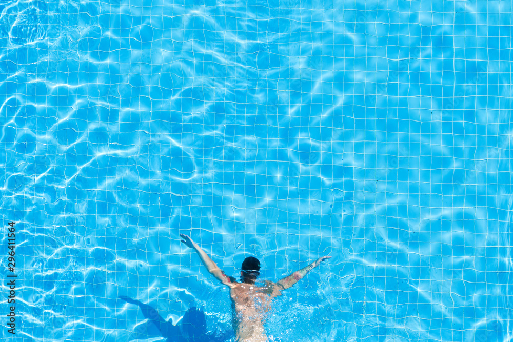 Top view of a man under water in a hotel pool.