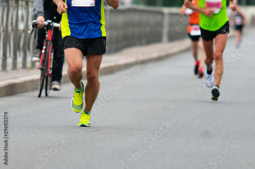 Legs of runners Marathon race on the city road. Runners and cyclist © watman