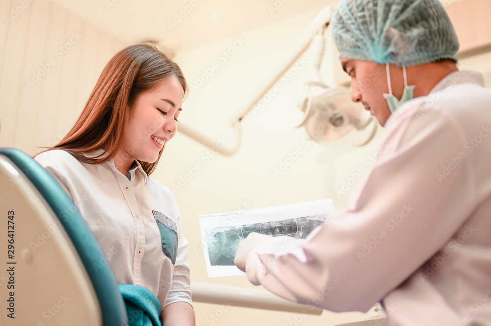 Fototapeta premium The dentist is looking at the patient's dental x-ray results for an effective treatment and improves the patient's dental health and a bright smile..