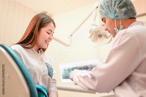 The dentist is looking at the patient's dental x-ray results for an effective treatment and improves the patient's dental health and a bright smile..