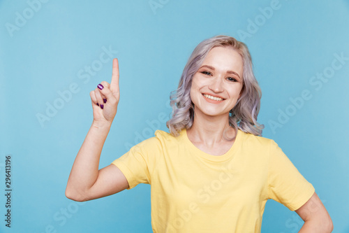 Portrait of happy girl pointing something by finger isolated