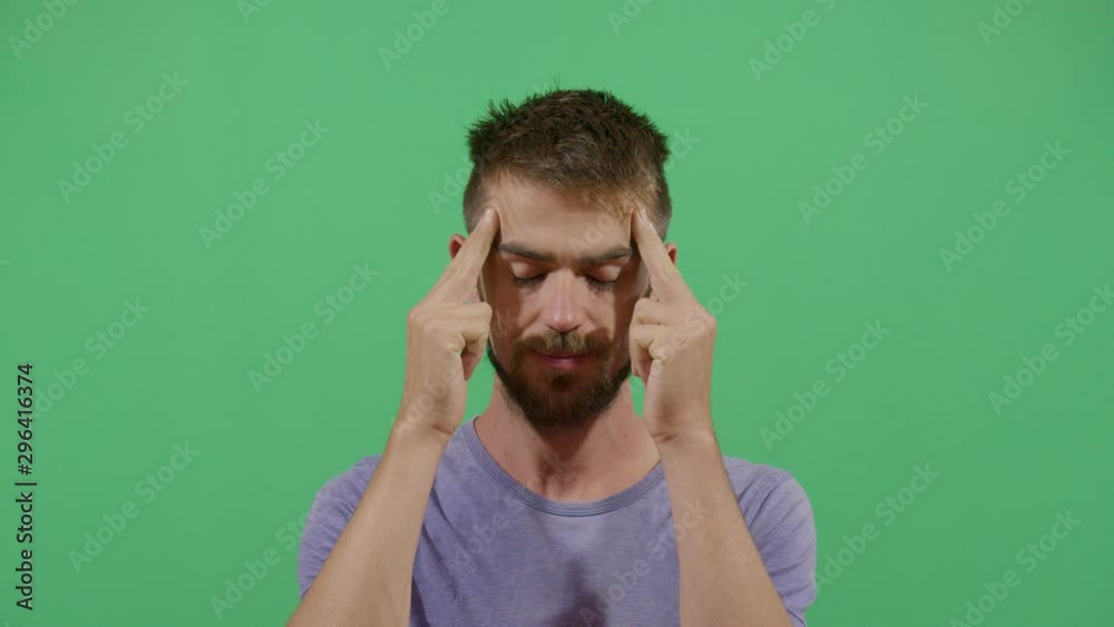 Adult Man Massaging The Temples With Eyes Closed Suggesting Head Ache. Studio Isolated Shot Against Green Screen Background Adult Man Massaging The Temples With Eyes Closed Suggesting Head Ache. Studio Isolated Shot Against Green Screen Background
