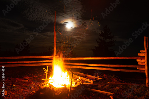 Tourists campfire, moonlight on mountains background, evening in autumn mountains, Carpathians, Ukraine