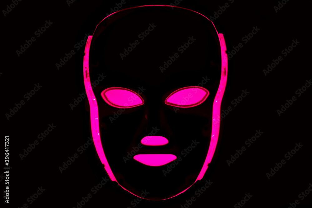 Color therapy mask glowing pink dark background Color therapy mask glowing pink dark background