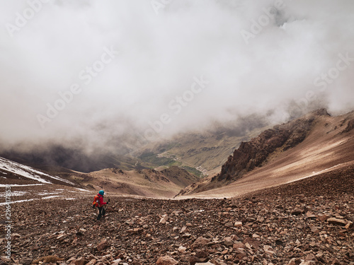 Tourist on hike descending to dramatic mountain valley of Tacheddirt