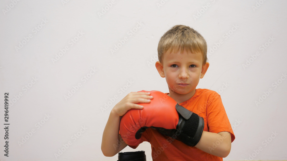 Kid practicing boxing with big red gloves Kid practicing boxing with big red gloves