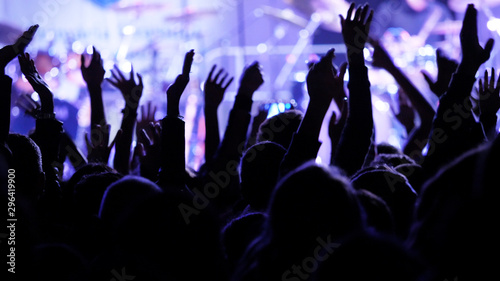 Crowd hands up and stage lights at night concert