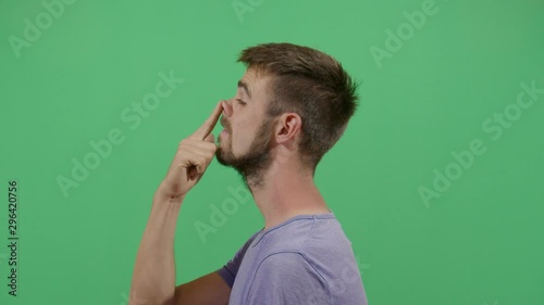 Side View Of A Adult Man Pushing On The Nose. Studio Isolated Shot Against Green Screen Background photo