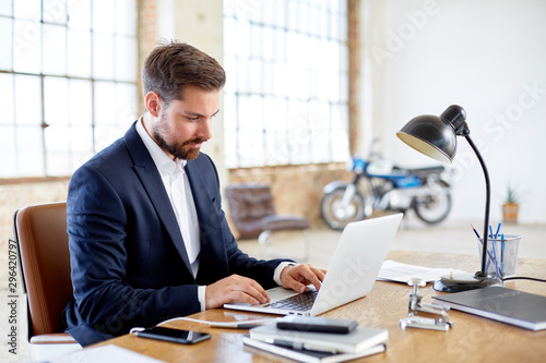 Businessman checking messages on his laptop