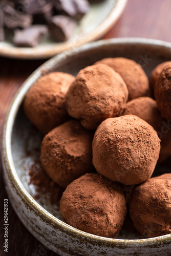 Dark chocolate truffles in a bowl, closeup view. Tasty chocolate candy