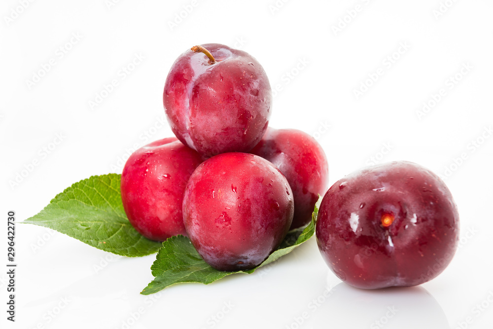 plums with plum leaves on a white background