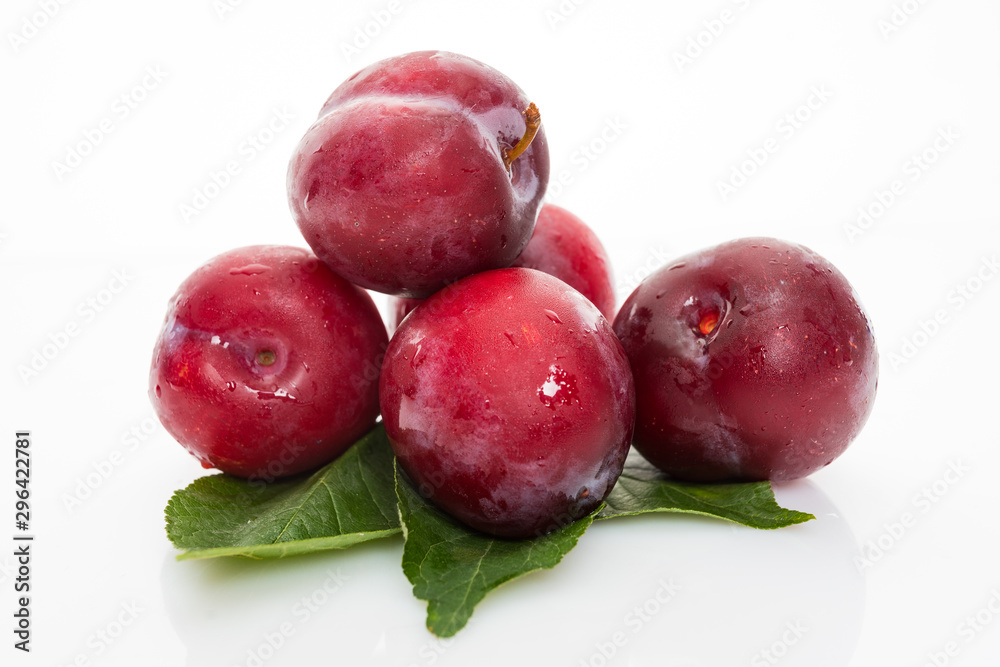 plums with plum leaves isolated on a white background