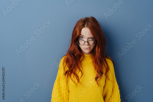Dubious young woman with glasses lowered photo