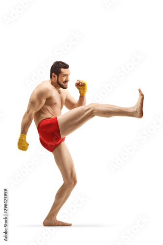 Fit man exercising kickboxing and pushing with his leg