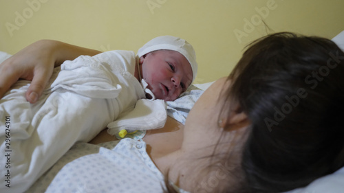 Portrait of new baby in mother arms in hospital, fist bounding