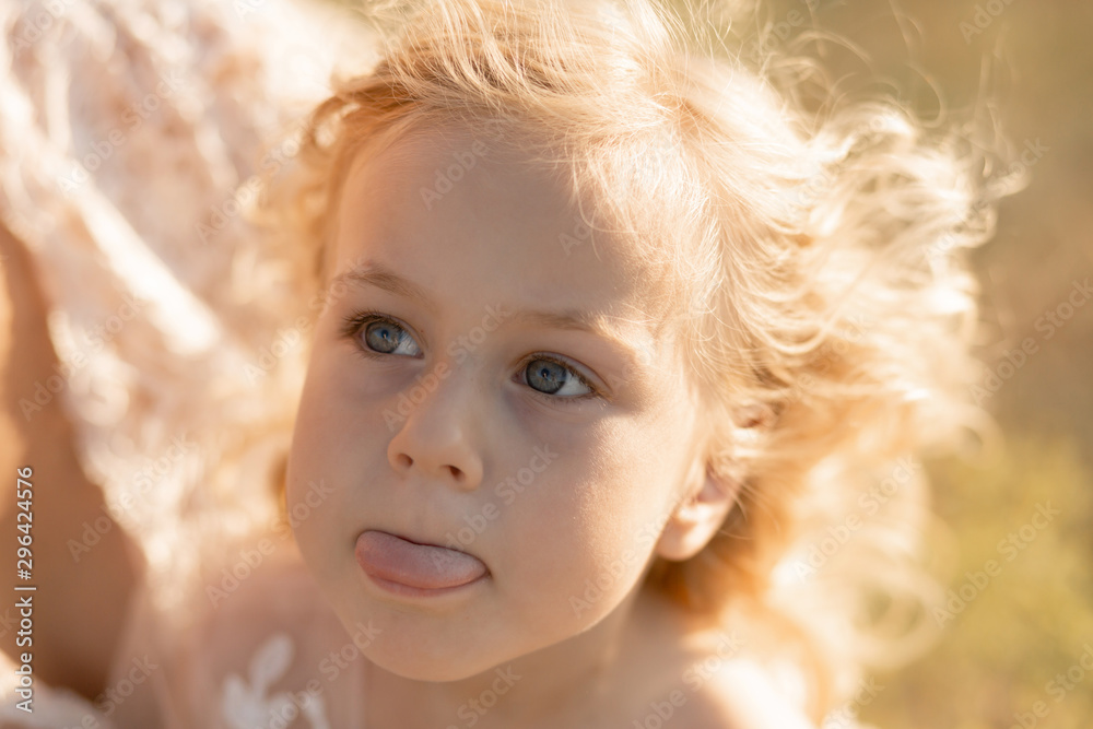 Portrait of a little girl shows tongue. The girl thought about something Portrait of a little girl shows tongue. The girl thought about something
