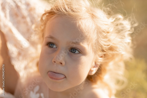 Portrait of a little girl shows tongue. The girl thought about something