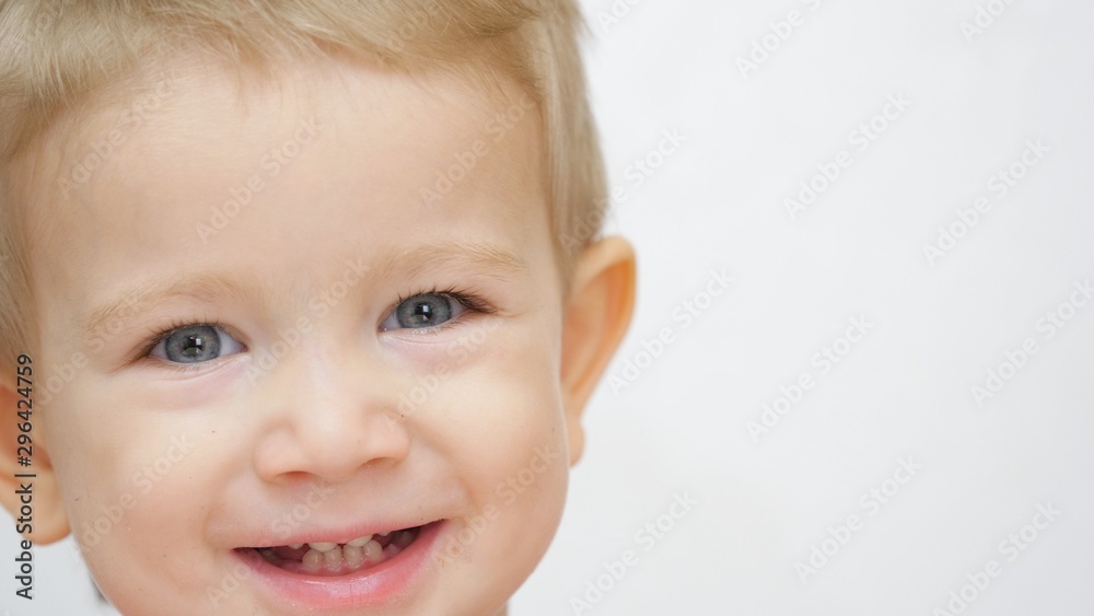 Child portrait, blond hair and blue eyes kid looking and smiling to camera