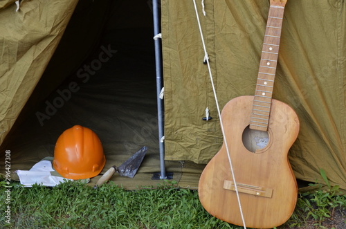 Tent with guitar in nature. Country picnic outdoors. Wild rest in the forest after a working day