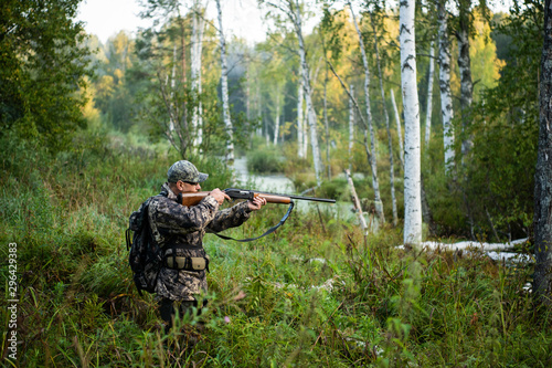 Hunter aiming with weapon at the outdoor hunting