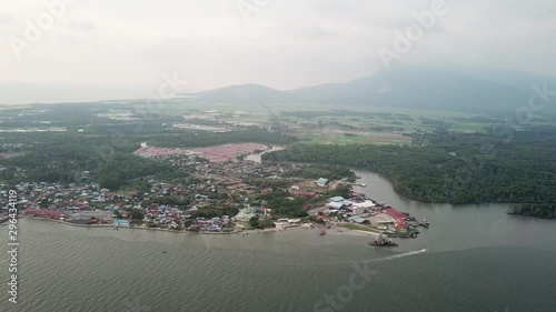 Aerial boat move along Merbok River near Tanjung Dawai. Background is Gunung Jerai, Kedah. photo