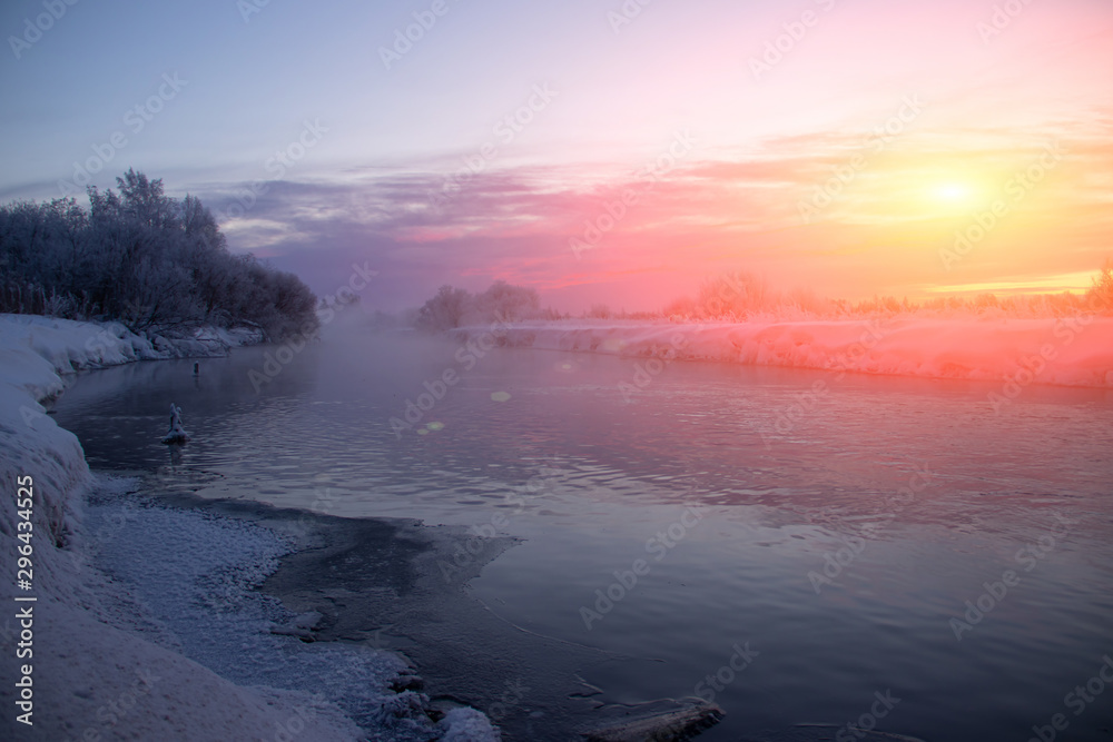 Morning dawn on the river in winter frost. Winter landscape. Morning m on the river. Severe frost. Evaporation from water.
