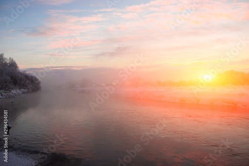 Morning dawn on the river in winter frost. Winter landscape. Morning m on the river. Severe frost. Evaporation from water.