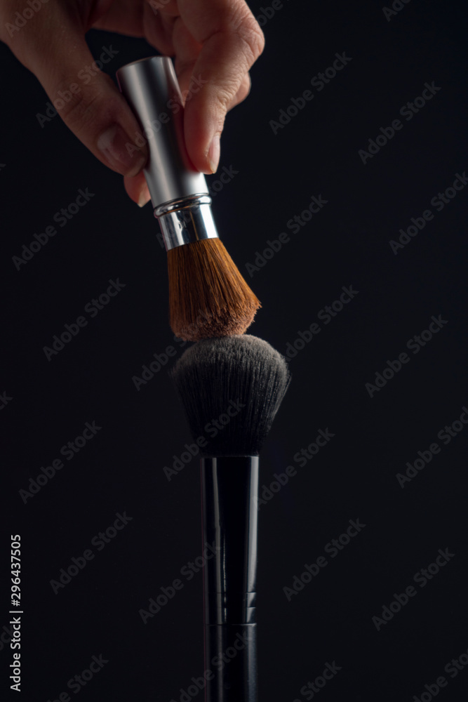 Fototapeta premium two powderbrush opposite each other on black background