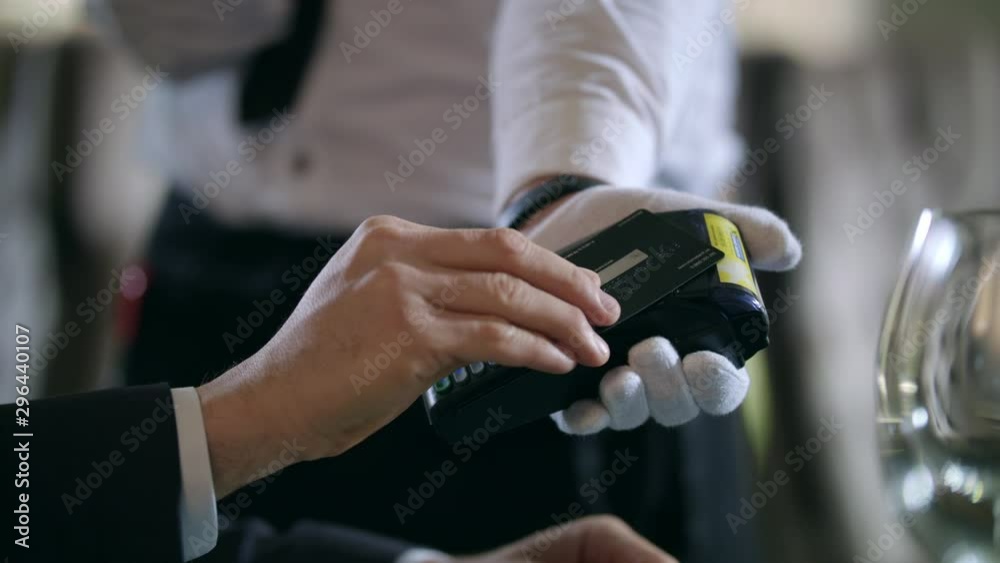 Male hands paying by credit card at terminal at restaurant. Credit card payment