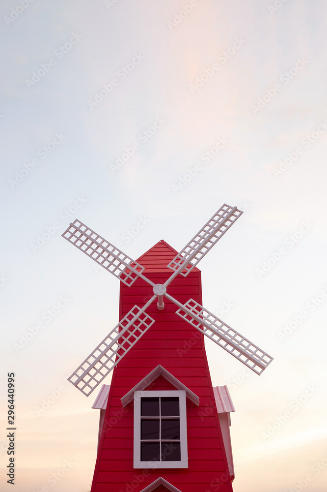 Red windmill in public park isolated in dust sky background