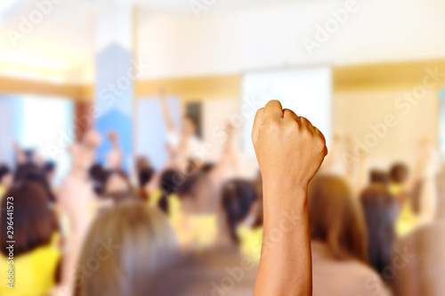 Audience raising hands up while businessman is speaking in training