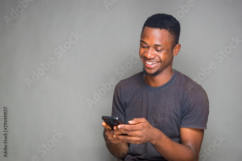 young african adult feeling very happy what he saw on his  phone.