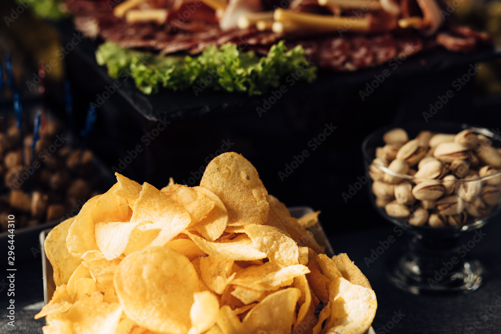 Close up of banquet table with different food Salty snacks. Pretzels, chips, crackers. Walnut, pistachios, almonds, hazelnuts and cashews Close up of banquet table with different food Salty snacks. Pretzels, chips, crackers. Walnut, pistachios, almonds, hazelnuts and cashews
