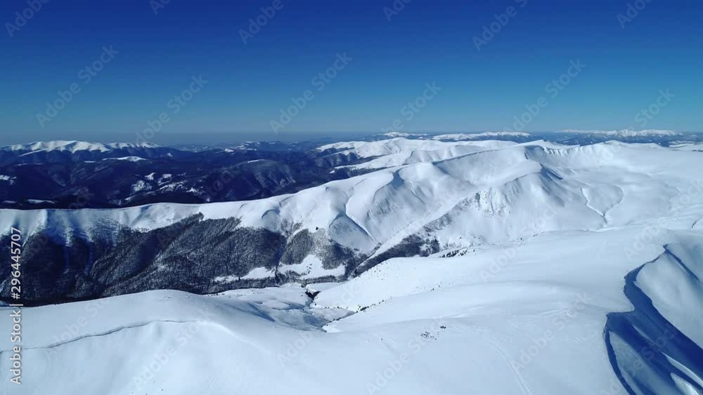 Flight over the turquoise snowy mountains illuminated by the day sun