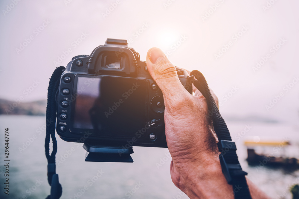Hand holding camera at rever background Stock Photo | Adobe Stock